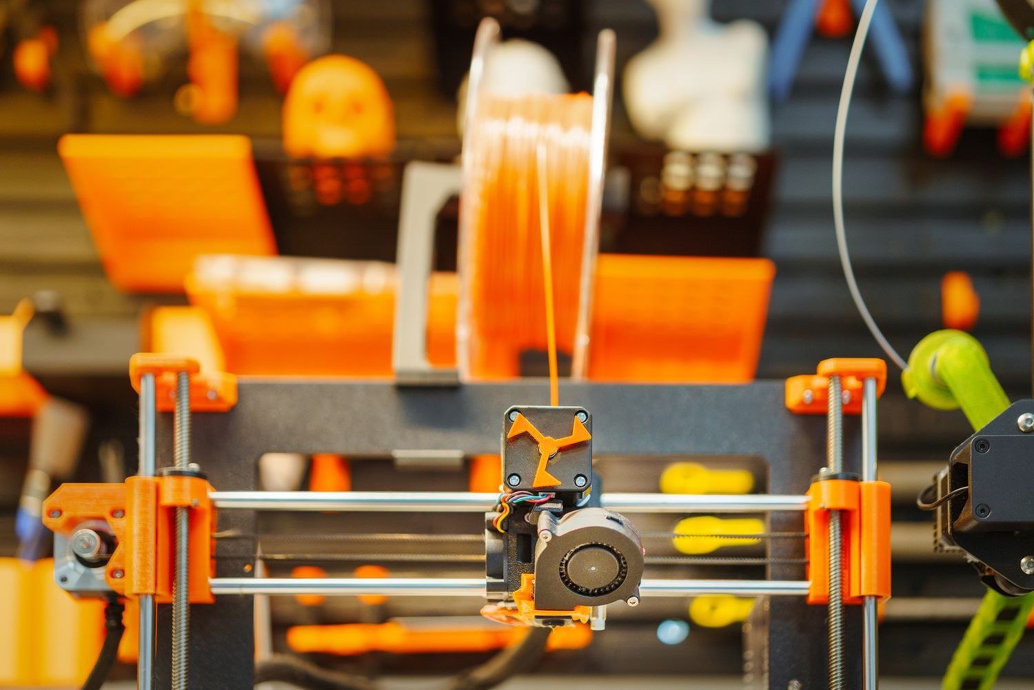 Close view of a desktop filament 3D printer and its print head